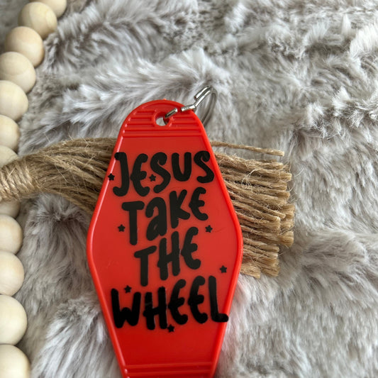 Red retro style keychain that says Jesus take the wheel