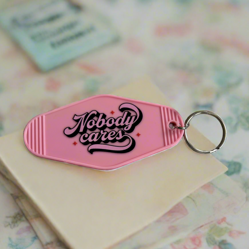 Retro motel keychain that says nobody care