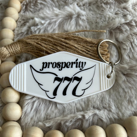 Retro vintage style keychain that has black angel numbers 777