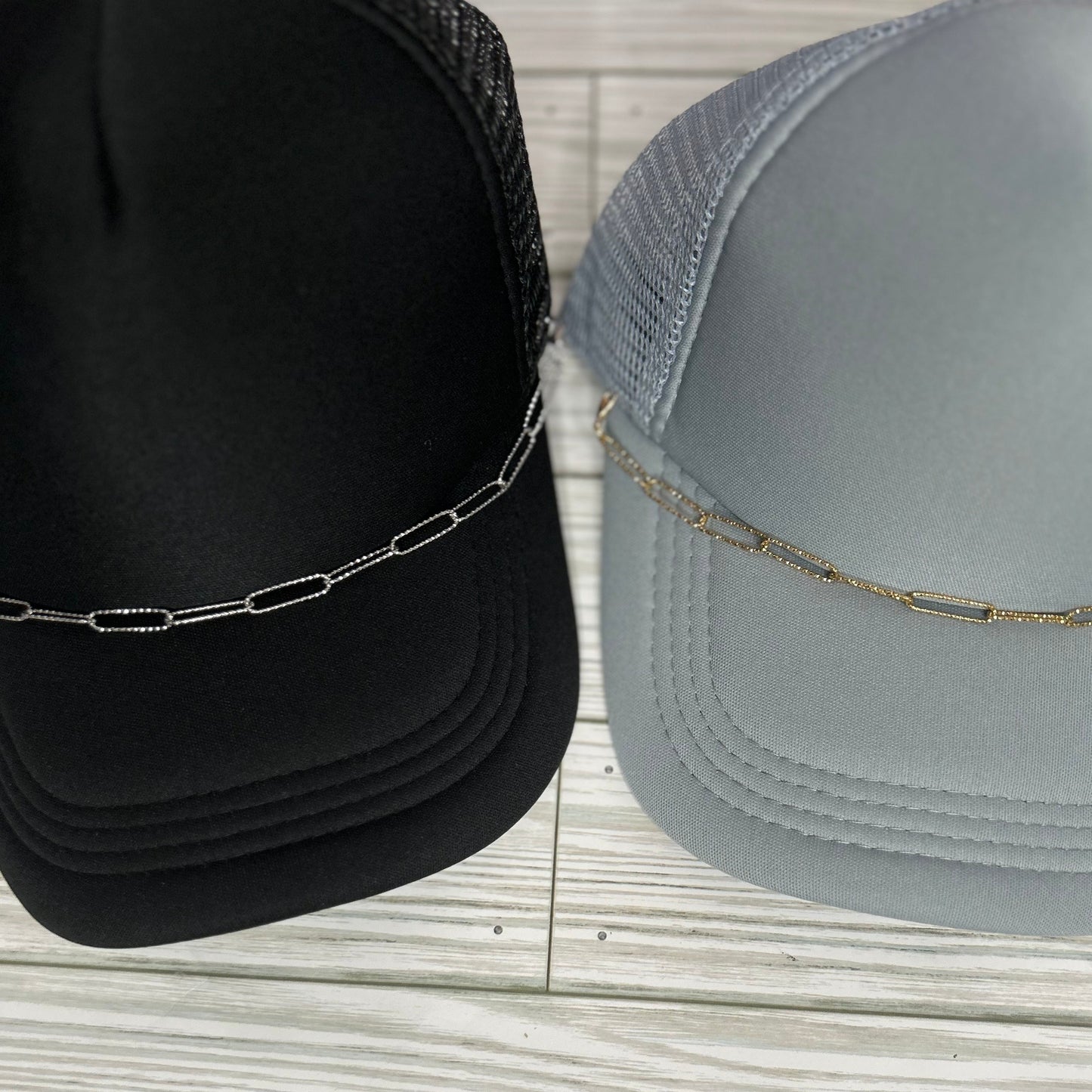 Embossed silver and gold paperclip trucker hat chain on a black and grey hat