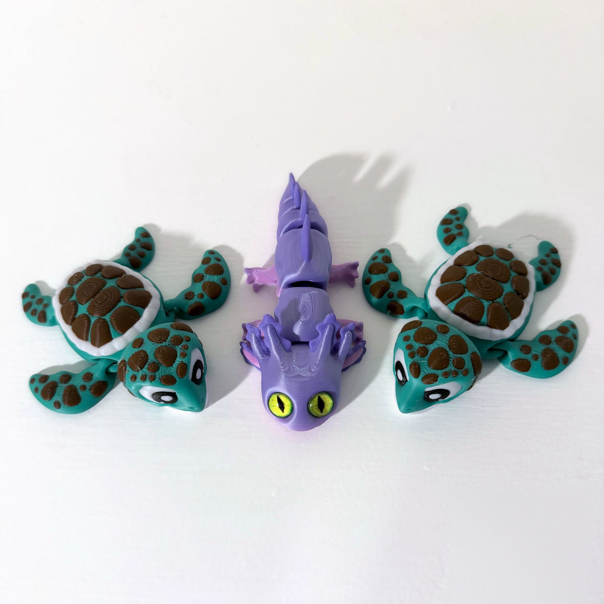 Axolotl and sea turtle fidget toys on a white shelf