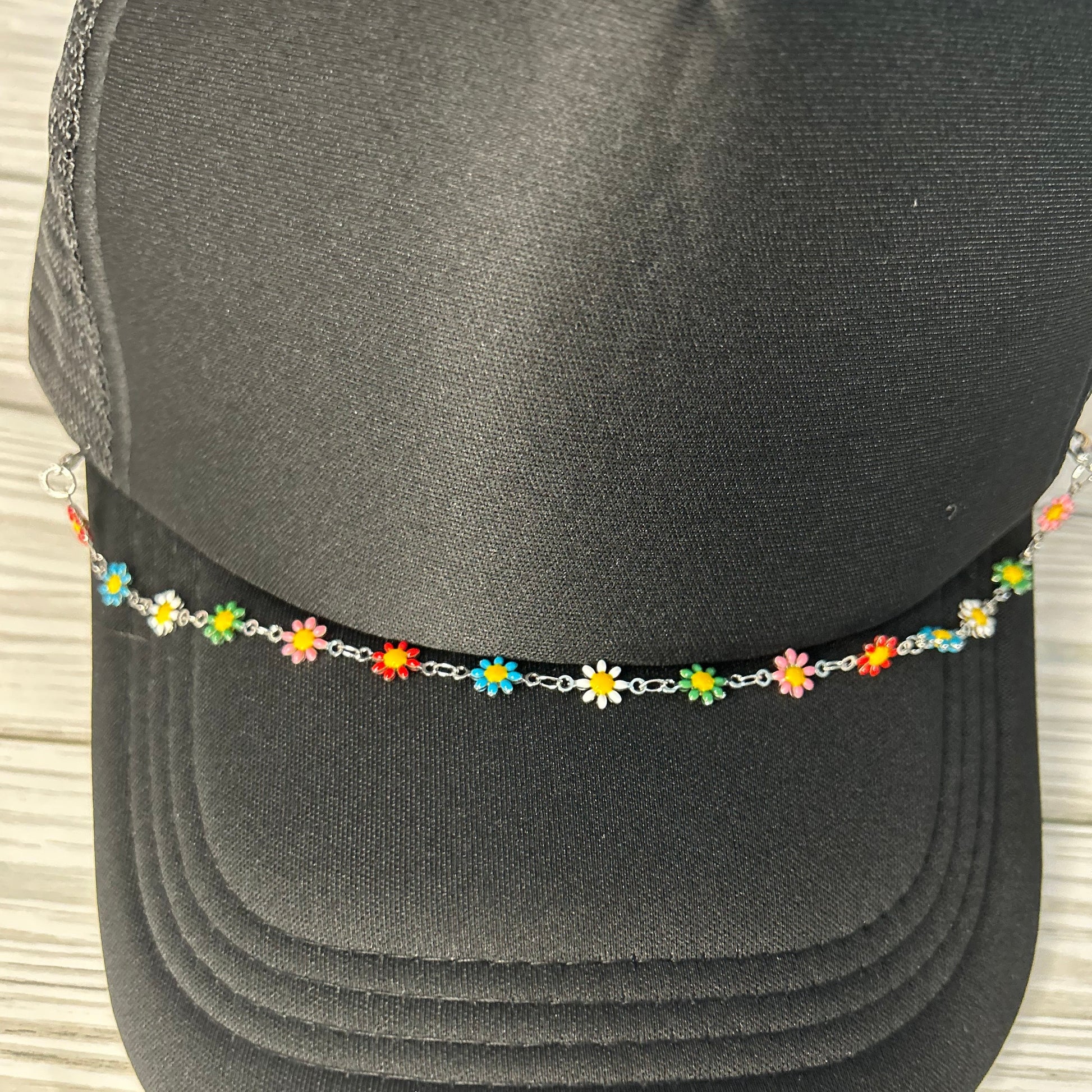 Multi colored daisy trucker hat chain on a black hat