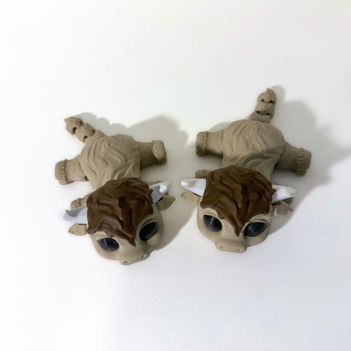 Pair of highland cow fidget toys on a white shelf