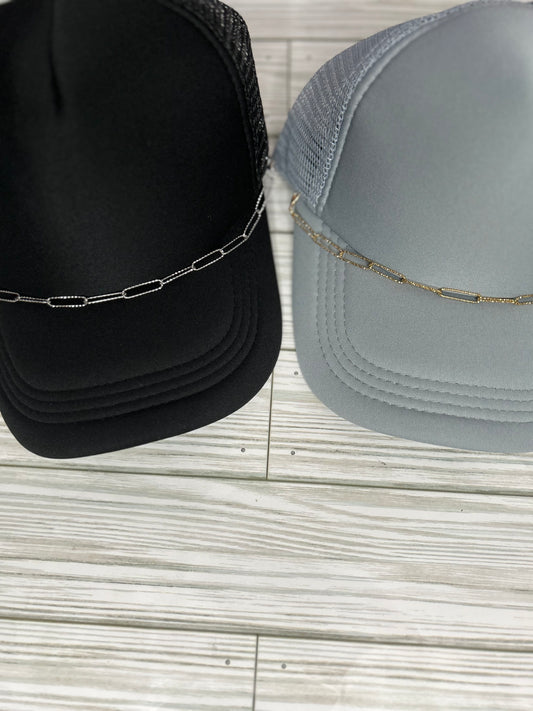 Embossed silver and gold paperclip trucker hat chain on a black and grey hat