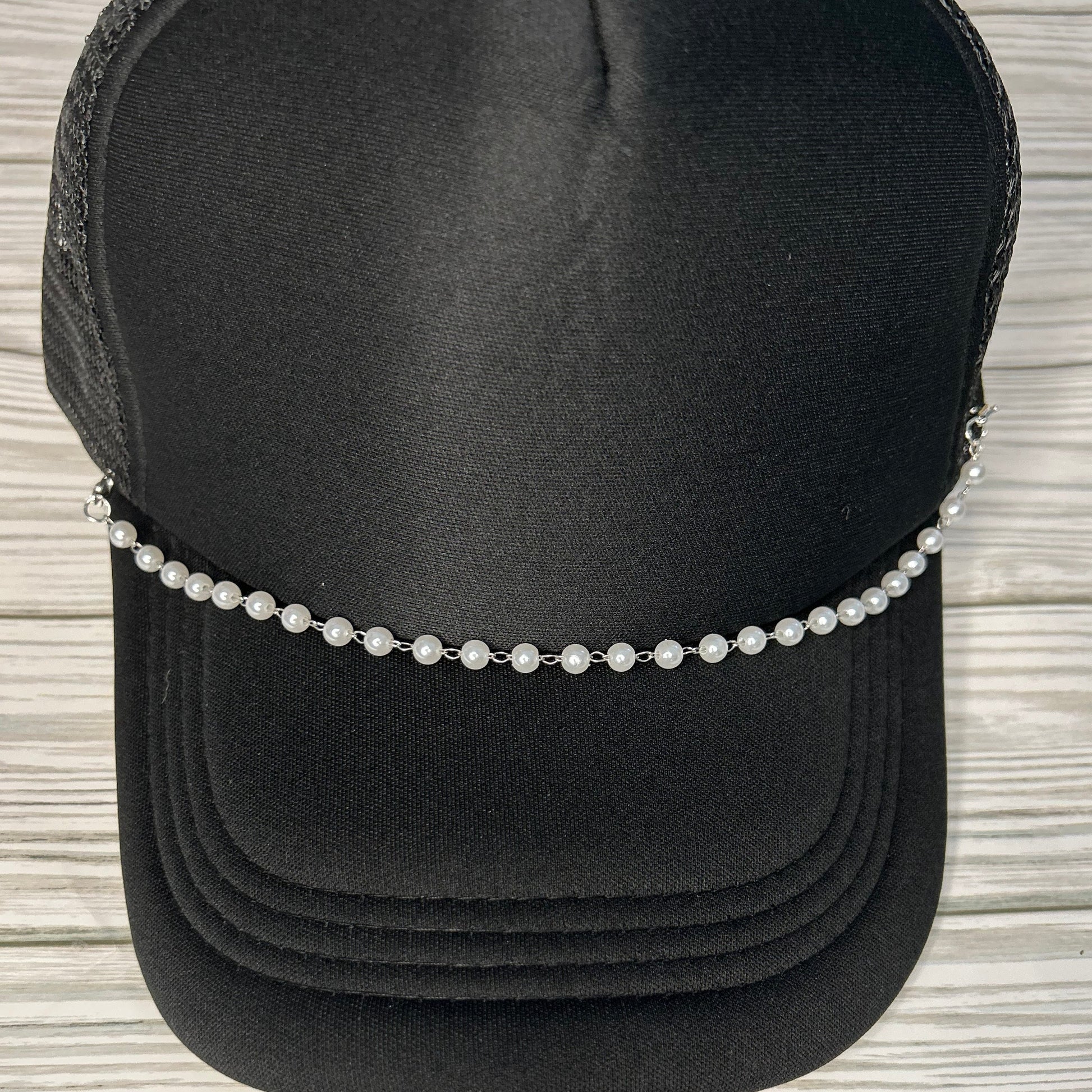 Pearl trucker hat chain on a black hat