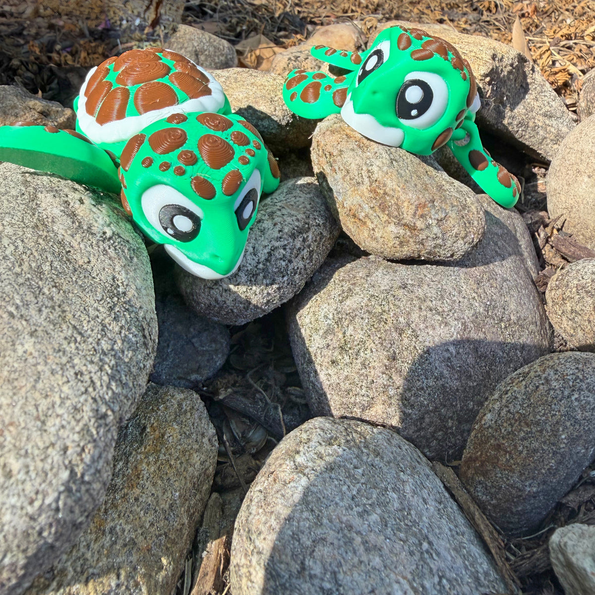 Pair of bright green 3D printed sea turtles outdoors